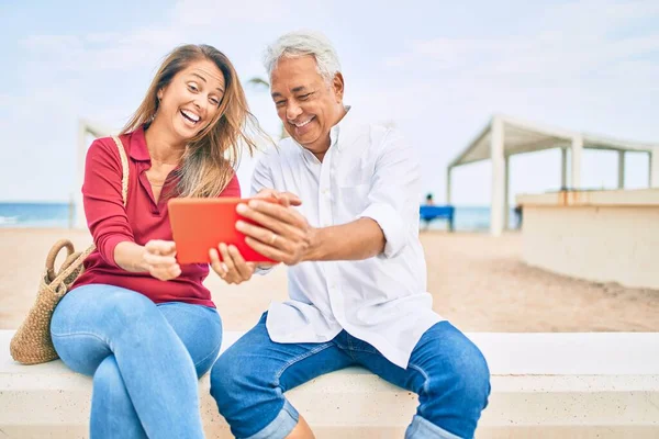 Middle Age Hispanic Couple Using Touchpad Sitting Bench Beach — Stock Photo, Image