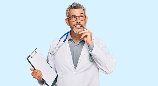 Hombre Pelo Gris Mediana Edad Con Estetoscopio Médico Sujetando Portapapeles —  Fotos de Stock
