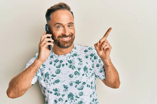 Bonito Homem Meia Idade Conversando Smartphone Sorrindo Feliz Apontando Com — Fotografia de Stock