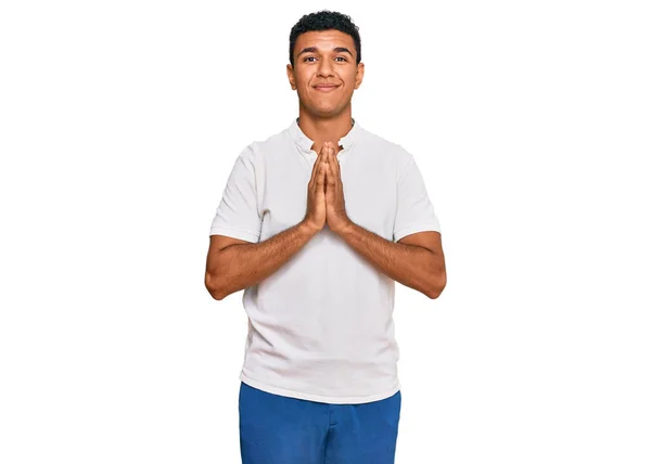 若いアラブ人の男が手で祈っているカジュアルな服を着て一緒に笑顔自信を許しを求めて — ストック写真