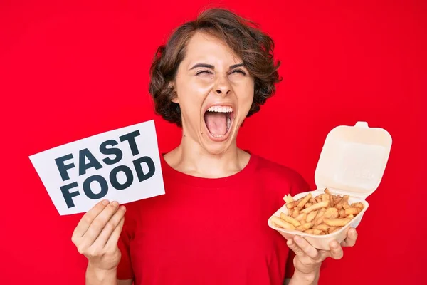 Jovem Hispânica Segurando Batata Frita Banner Fast Food Irritado Louco — Fotografia de Stock