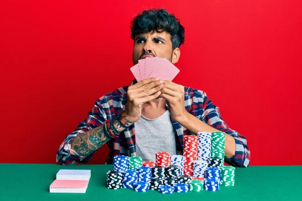 Jovem Hispânico Jogando Poker Cobrindo Rosto Com Cartas Com Raiva — Fotografia de Stock