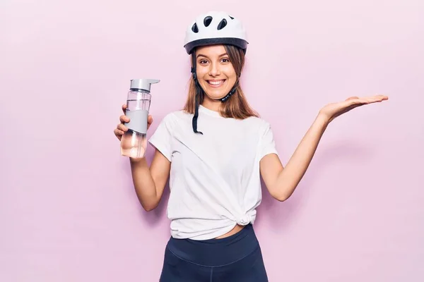 若いです美しいです女の子身に着けています自転車ヘルメット飲料ボトルの水幸せな笑顔と受賞式とともに上げ手 — ストック写真