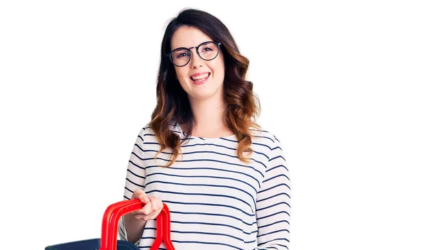 Schöne Junge Brünette Frau Mit Supermarkt Einkaufskorb Sieht Positiv Und — Stockfoto