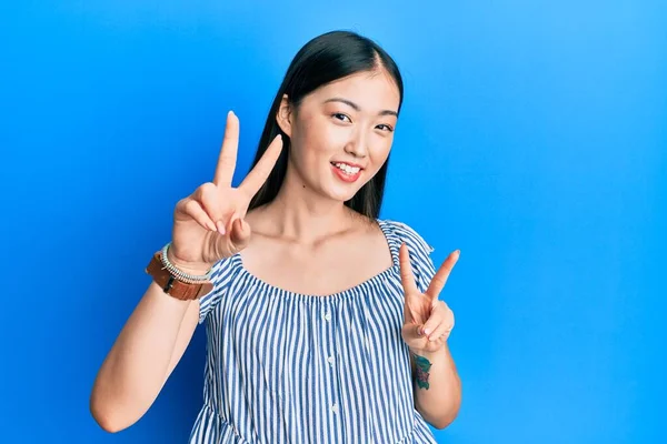 Νεαρή Κινέζα Γυναίκα Που Φοράει Casual Ριγέ Shirt Χαμογελώντας Κοιτάζοντας — Φωτογραφία Αρχείου