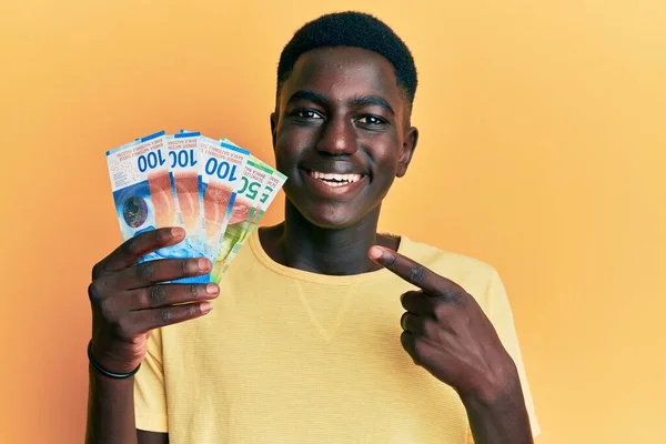 손가락으로 행복하게 가리키며 스위스 지폐를 아프리카계 미국인 — 스톡 사진