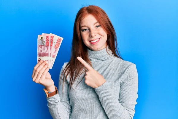Młoda Ruda Dziewczyna Trzyma 500 Szwedzkich Banknotów Korony Uśmiechając Szczęśliwy — Zdjęcie stockowe