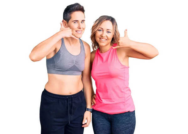 Couple Women Wearing Sportswear Smiling Doing Phone Gesture Hand Fingers — Stock Photo, Image