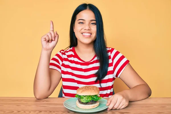 Fiatal Ázsiai Lány Eszik Egy Ízletes Klasszikus Hamburgert Meglepett Egy — Stock Fotó