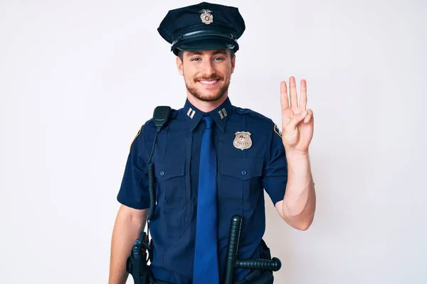 Young caucasian man wearing police uniform showing and pointing up with fingers number three while smiling confident and happy.