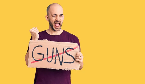 Young Handsome Man Holding Prohibited Guns Banner Screaming Proud Celebrating — Stock Photo, Image