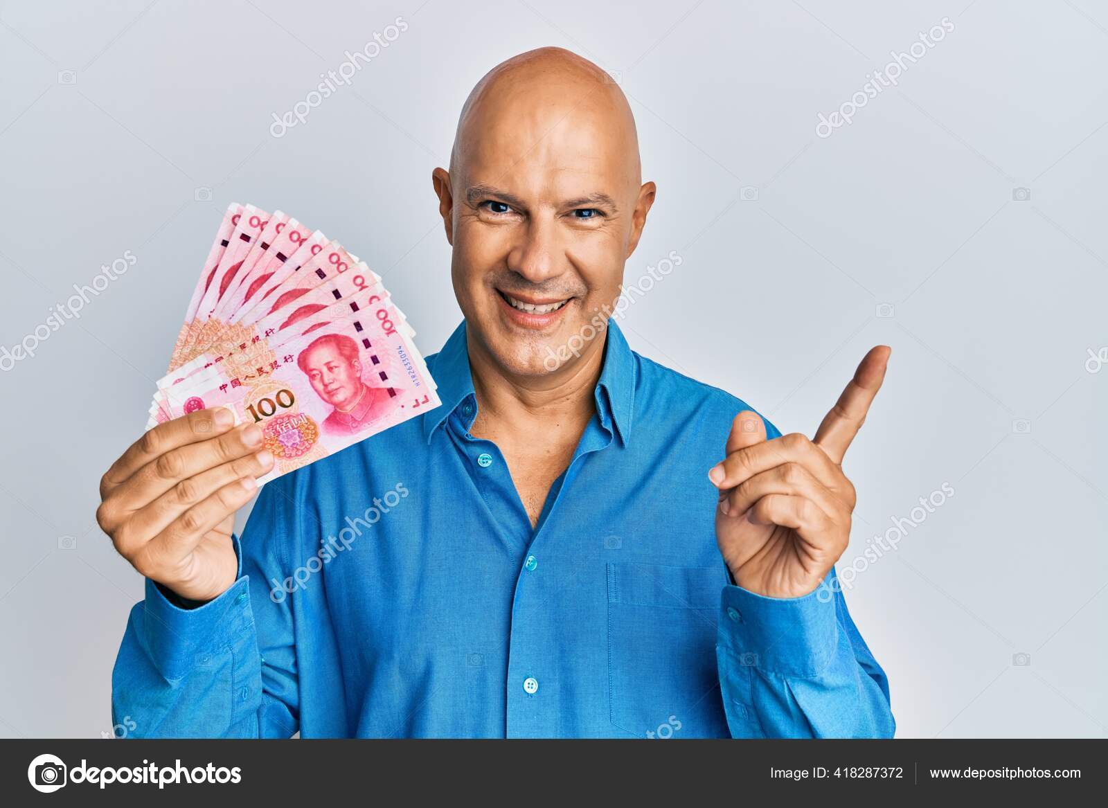 中年男人手里拿着100元人民币钞票笑容满面手指手画脚——图库图片© Krakenimages.com #418287372