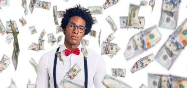 Afro saçlı yakışıklı Afro-Amerikan bir adam. Yüzünde ciddi bir ifade olan zarif bir hippi görünüşü var. Basit ve doğal bir şekilde kameraya bakıyorsun..