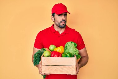 Yakışıklı, sakallı, üniformalı, teslimatçı, hiçbir şeyden haberi olmayan, kafası karışık bir adam. şüphe kavramı. 