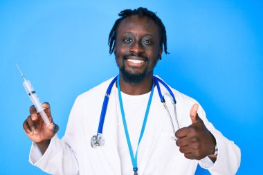 Örgülü, doktor steteskobu takan, elinde şırıngayla gülümseyen, mutlu ve pozitif gülümseyen genç Afro-Amerikalı bir adam. 