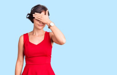 Kısa saçlı, sıradan giyinen, kolsuz tişörtlü, gözleri elle kaplanmış, ciddi ve üzgün görünen güzel bir genç kadın. Görme, saklama ve reddetme konsepti 