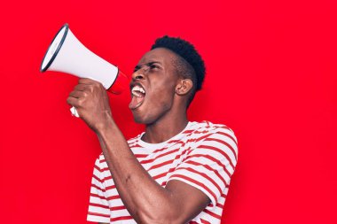 Genç Afrikalı adam kızgın bir şekilde megafondan bağırıyor.