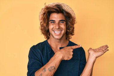 Yaz şapkası takan genç İspanyol adam kameraya hayret ediyor ve gülümsüyor.. 