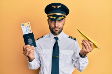 Elinde kağıt uçak ve pasaport tutan yakışıklı İspanyol pilot. Şüpheci ve gergin. Sorun yüzünden surat asıyor. negatif kişi. 