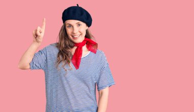 Fransız bereli ve çizgili tişörtlü güzel sarışın kadın başarılı bir fikri işaret ediyor. Heyecanlı ve mutlu. Bir numara.. 