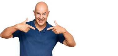 Orta yaşlı, kel, günlük kıyafetler giyen, kendine güvenen, yüzünde gülümseme olan, kendini gururlu ve mutlu gösteren bir adam.. 