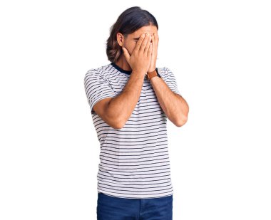 Genç, yakışıklı, sıradan kıyafetler giyen, suratını ellerle örten ve ağlayan bir adam. depresyon kavramı. 