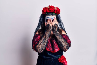 Beyaz üzerine ölü kostümü giymiş genç bir kadın. Ağlarken suratını ellerle kapatan üzgün bir ifade. depresyon kavramı. 