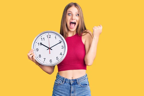 Jovem Bela Mulher Loira Segurando Grande Relógio Gritando Orgulhoso Celebrando — Fotografia de Stock