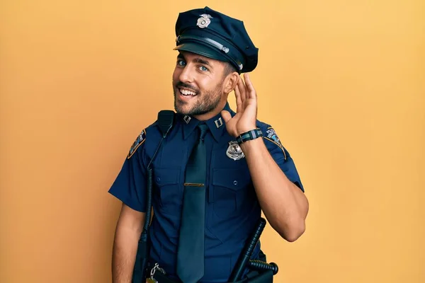 Bonito Hispânico Vestindo Uniforme Policial Sorrindo Com Mão Sobre Ouvido — Fotografia de Stock