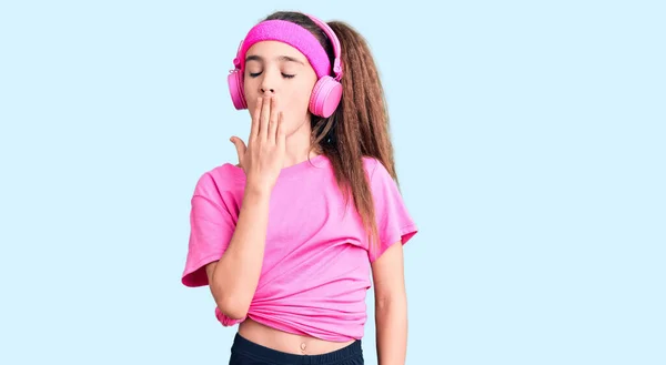 Linda Niña Hispana Vistiendo Ropa Gimnasio Usando Auriculares Aburridos Bostezando —  Fotos de Stock