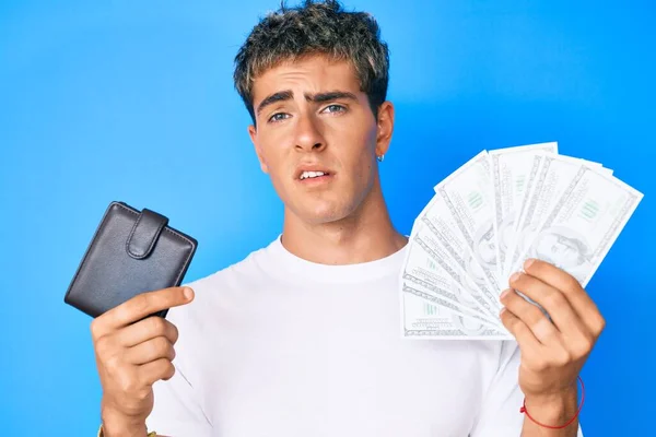 Joven Hombre Guapo Sosteniendo Billetera Billetes Dólares Expresión Despistada Confusa —  Fotos de Stock