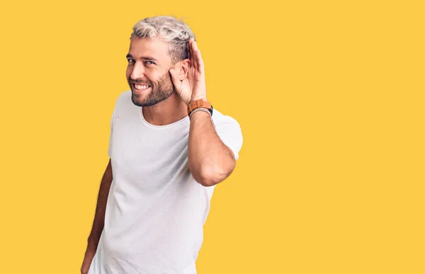 Joven Hombre Rubio Guapo Con Camiseta Casual Sonriendo Con Mano —  Fotos de Stock