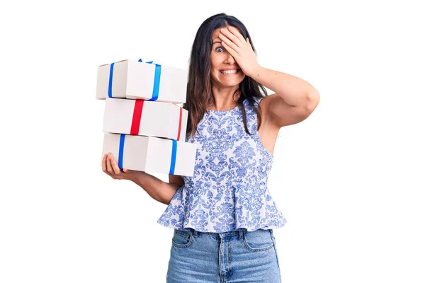 Young Beautiful Brunette Woman Holding Birthday Gift Stressed Frustrated Hand — Stock Photo, Image