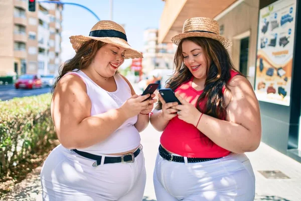 2プラスサイズ太りすぎ姉妹双子女性とともにスマートフォン屋外で晴れた日に — ストック写真
