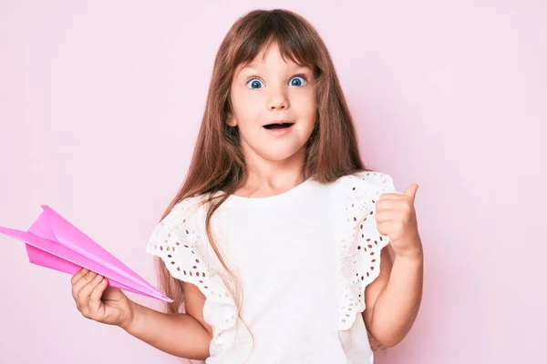 Pequena Menina Caucasiana Com Cabelos Longos Segurando Avião Papel Apontando — Fotografia de Stock