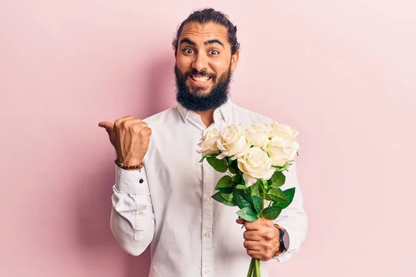 Ung Arabisk Man Med Blommor Pekar Tummen Upp Till Sidan — Stockfoto