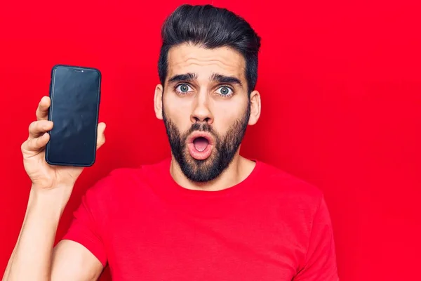 Sakallı Akıllı Telefonlu Genç Bir Adam Ekranda Korkmuş Ağzı Açık — Stok fotoğraf