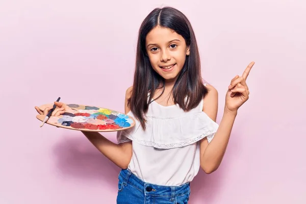 Hermosa Niña Sosteniendo Pincel Paleta Sonriendo Feliz Señalando Con Mano —  Fotos de Stock