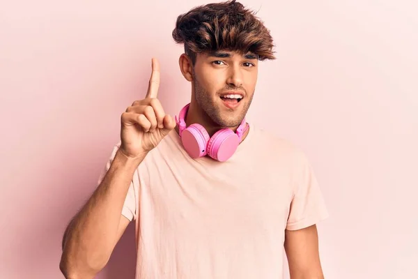 Joven Hispano Escuchando Música Usando Auriculares Sonriendo Con Una Idea —  Fotos de Stock