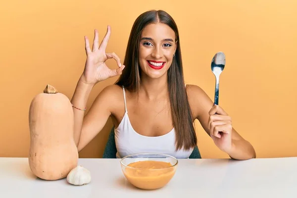 Giovane Donna Ispanica Mangiare Zuppa Zucca Con Cucchiaio Facendo Segno — Foto Stock