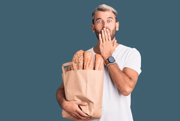 Homem Loiro Bonito Jovem Segurando Saco Papel Com Pão Cobrindo — Fotografia de Stock