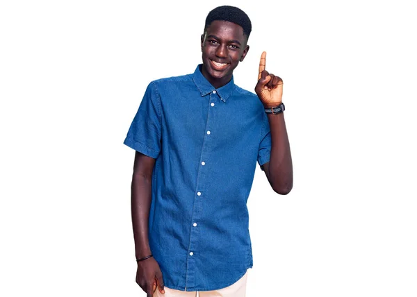 カメラを見ている側に手の指で指して 顔に大きな笑顔でカジュアルな服を着て若いアフリカ系アメリカ人の男 — ストック写真