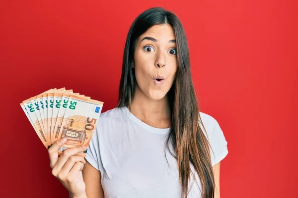 Young Brunette Woman Holding Euro Banknotes Scared Amazed Open Mouth — Stock Photo, Image