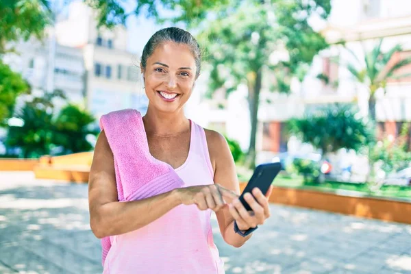 Medelålders Idrottskvinna Ler Glad Med Smartphone Parken — Stockfoto