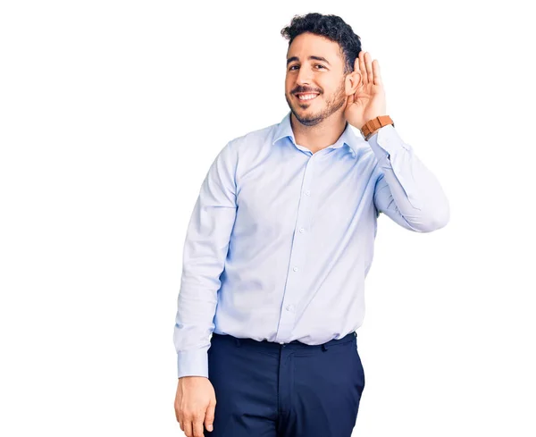 噂やゴシップに耳を傾ける耳の上に手で笑みを浮かべてビジネス服を着て若いヒスパニック系の男 聴覚障害の概念 — ストック写真