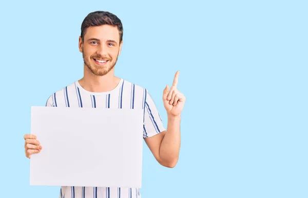 Jovem Bonito Com Urso Segurando Banner Vazio Branco Surpreso Com — Fotografia de Stock