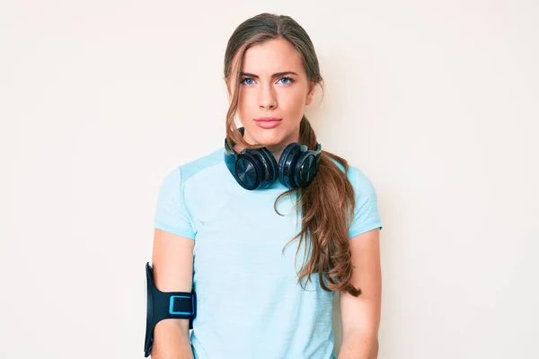 Schöne Junge Kaukasische Frau Turnbekleidung Und Mit Kopfhörern Skeptisch Und — Stockfoto