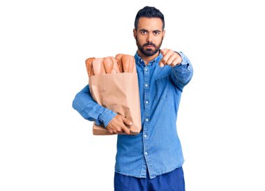 Elinde ekmek olan genç İspanyol bir adam kamerayı işaret ediyor. Kendine güvenen bir jest, ciddi görünüyor. 