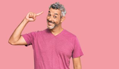 Orta yaşlı, gri saçlı, günlük kıyafetler giyen, gülümseyen, tek parmakla işaret eden, harika bir fikir ya da düşünce, iyi bir hafıza. 