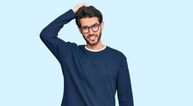 Gündelik kıyafet ve gözlük takan genç İspanyol adam soru sorup kafasını karıştırıyor. Şüpheyle kararsız, kafa kafaya düşünerek. Düşünceli kavram. 